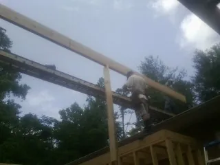 Carpenter setting a ridge beam over a new addition frame — Ice Dam Removal by Roofing Brothers in Raleigh