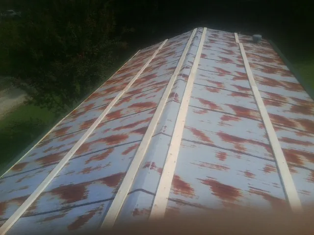 Rusted metal roof panels with new wood purlins before replacement — Storm Damage Roof Repair in Raleigh by Roofing Brothers