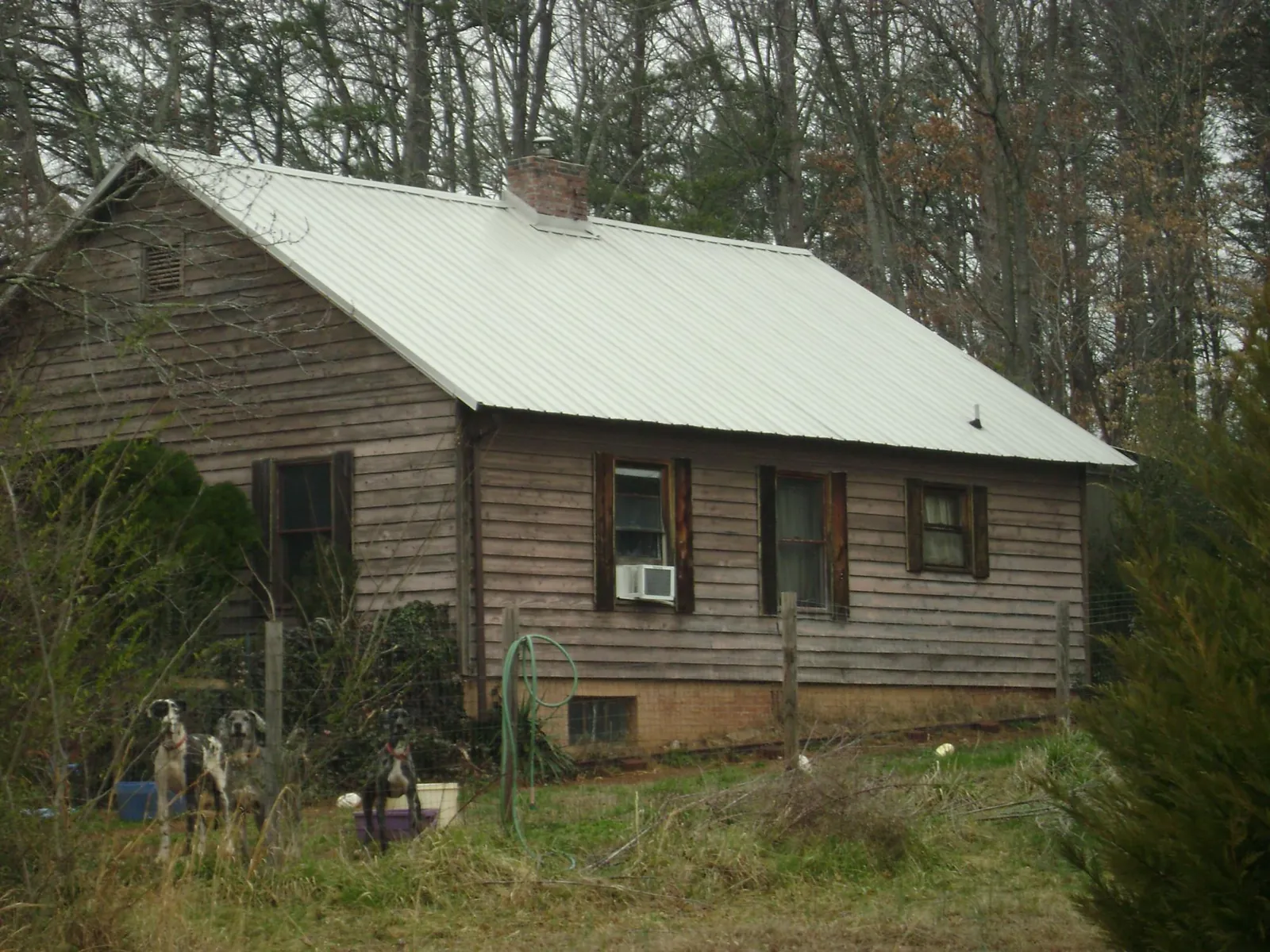 White metal roof on an old wood sided farmhouse, from a Metal Roof Installation job in Raleigh